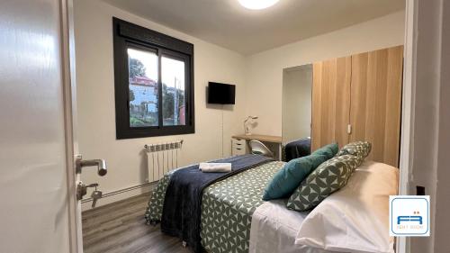 Schlafzimmer mit einem Bett und einem Fenster in der Unterkunft Amplia casa de 9 hab, Cabral. in Vigo