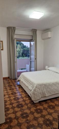 a bedroom with a bed and a sliding glass door at Casa Stazione Magliana in Rome