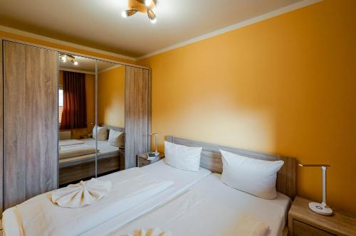 Schlafzimmer mit einem großen weißen Bett und einem Spiegel in der Unterkunft di Holting Hüs in Westerland