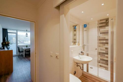 ein Bad mit einem Waschbecken und einer Glasdusche in der Unterkunft di Holting Hüs in Westerland