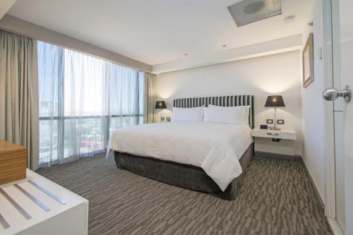 una camera d'albergo con un letto e una grande finestra di Presidente InterContinental Guadalajara, an IHG Hotel a Guadalajara