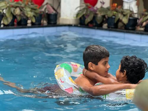 due ragazzi in una piscina con camera d'aria di Casita Greenacres Homestay a Vythiri
