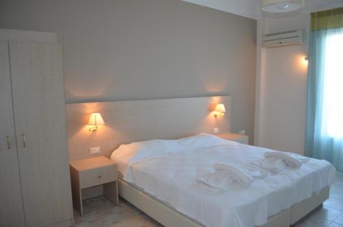 a bedroom with a white bed and two night stands at Archontissa in Ermoupoli