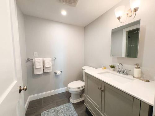 Baño blanco con aseo y lavamanos en Charming Hyannis 3 Bed 2 Bath en Barnstable