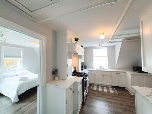 een keuken met witte kasten en een bed in een kamer bij Water Access 5-Bed 2-Bath Retreat in Barnstable