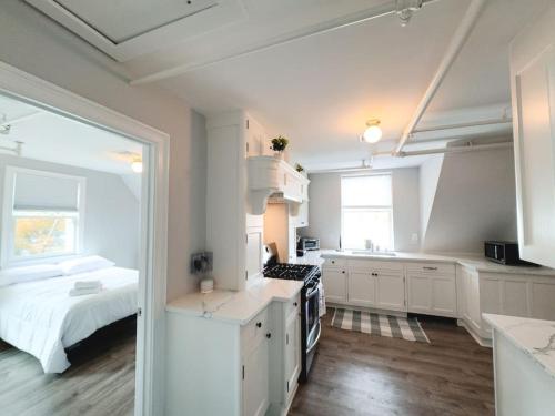 a kitchen with white cabinets and a bed in a room at Water Access 5-Bed 2-Bath Retreat in Barnstable