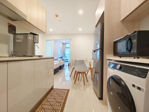 a kitchen with a microwave and a dining room at Lasa Lasa Sojourn 4 pax at The Shore seaview suites in Kota Kinabalu