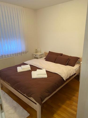 a bedroom with a bed with two towels on it at Pranjić Apartment in Zaprešić