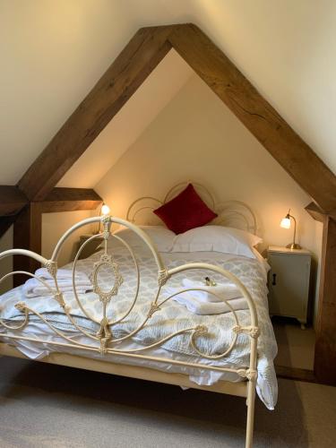 una camera da letto con letto bianco in mansarda di Stable Cottage a Dorking