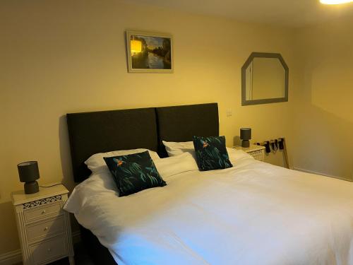una camera da letto con un grande letto bianco con due cuscini di Cosy Hillside Annex a Stanwick