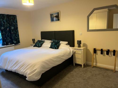 una camera da letto con un grande letto bianco con cuscini blu di Cosy Hillside Annex a Stanwick