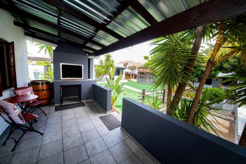 a patio with a table and chairs and a television at Kleinplasie Guesthouse in Springbok