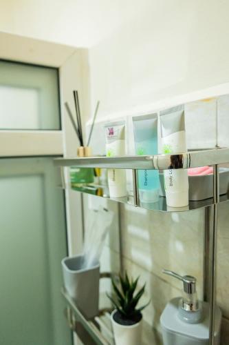 a shelf with toiletries on it in a bathroom at Premier Suites Kyanja in Kampala