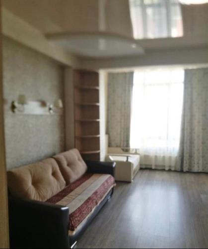 uma sala de estar com um sofá e uma grande janela em VIP apart 413 em Tbilisi