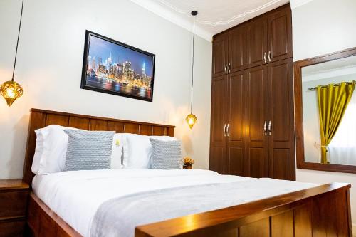 a bedroom with a bed and a tv on the wall at Premier Suites Kyanja in Kampala