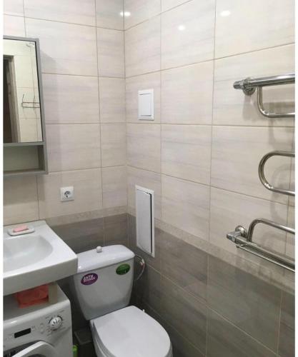 uma casa de banho com um WC branco e um lavatório. em VIP apart 413 em Tbilisi