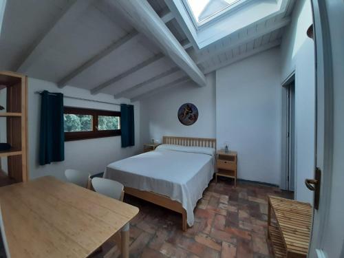 een slaapkamer met een bed, een tafel en een raam bij Agriturismo la Romanella in Viterbo