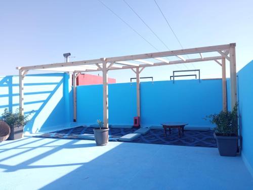 eine Terrasse mit einer blauen Wand und einem Picknicktisch in der Unterkunft Flat Al farabi in Agadir