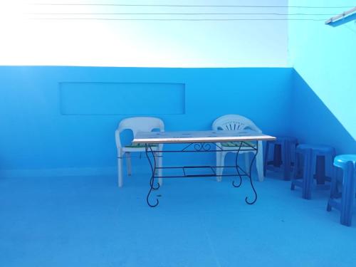 2 Stühle und ein Tisch in einem blauen Zimmer in der Unterkunft Flat Al farabi in Agadir