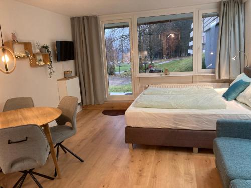 a bedroom with a bed and a table and chairs at Wildwood Lodge Ferienwohnung mit Wellness in Sankt Englmar