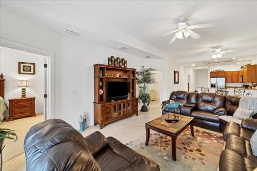 a living room with leather couches and a tv at 3329 Purple Martin 112 in Punta Gorda