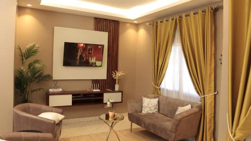 a living room with a couch and a chair at Premier Suites Kyanja in Kampala