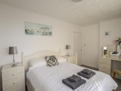 a bedroom with a white bed with towels on it at Ewyn Gwyn in Pwllheli