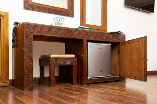 a wooden fireplace with a small refrigerator in a room at Dar Zayane in Khenifra