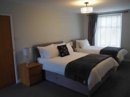 a bedroom with two beds and a window at Stone Cottage in Morpeth