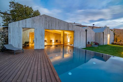 a house with a swimming pool and a wooden deck at in Bulla, Country and Wellness - Turismo Rural in Seixo do Côa