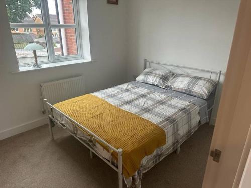 Bett in einem Zimmer mit Fenster in der Unterkunft Immaculate house in Doncaster in Cantley