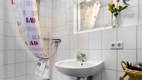 a white bathroom with a sink and a mirror at Haus Heinemann in Stegen