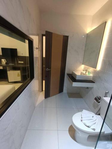 a bathroom with a toilet and a sink at I AM O'TEL Patong in Patong Beach