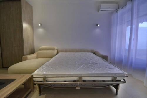 - un lit dans une chambre à côté d'un canapé dans l'établissement 2 pièces de Jonathan - Juan les Pins centre - proche plages, à Juan-les-Pins