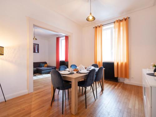 una sala da pranzo e un soggiorno con tavolo e sedie. di Le Haut Cloquais - SereniStay a Metz