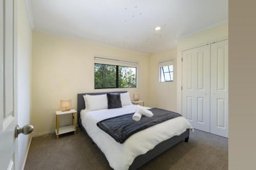 une chambre avec un lit et une fenêtre dans l'établissement Spa, Movies, Pool table, Table tennis in Ellerslie!, à Auckland