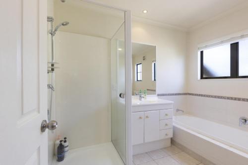 une salle de bain avec une douche, une baignoire et un lavabo dans l'établissement Spa, Movies, Pool table, Table tennis in Ellerslie!, à Auckland