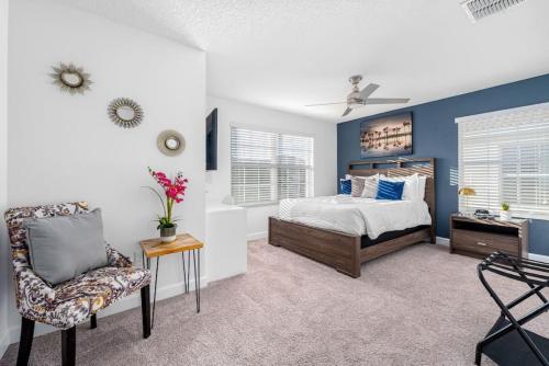 1 dormitorio con paredes azules, 1 cama y 1 silla en New - Champions Gate 5-Bedroom, en Davenport