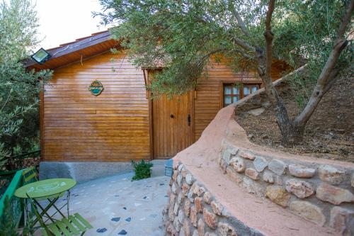 a wooden cabin with a stone wall and a table at Dar Zayane in Khenifra