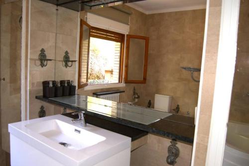La salle de bains est pourvue d'un lavabo et d'un miroir. dans l'établissement Villa Olga, à Gérone