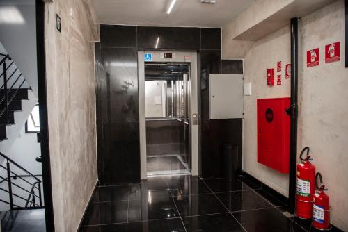 a bathroom with a walk in shower with a red door at Uny Hotéis Brás in Sao Paulo