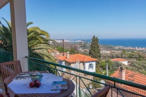 balcón con mesa y vistas al océano en Μυτιλήνη Ταξιάρχες en Mitilene