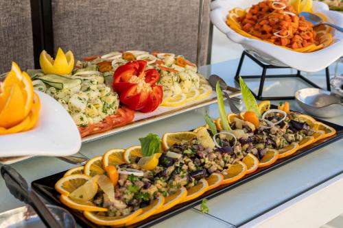 two trays of food on a table with plates of food at Grand Mogador Sea View & Spa in Tangier