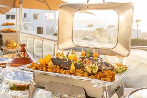 a tray of food on a buffet table with food at Grand Mogador Sea View & Spa in Tangier