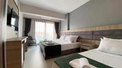 ein Hotelzimmer mit 2 Betten und einem TV in der Unterkunft Medos Hotel in Kusadası