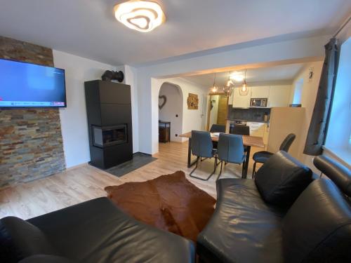 a living room with a couch and a table with chairs at Haus Eder Steiner in Saalbach Hinterglemm
