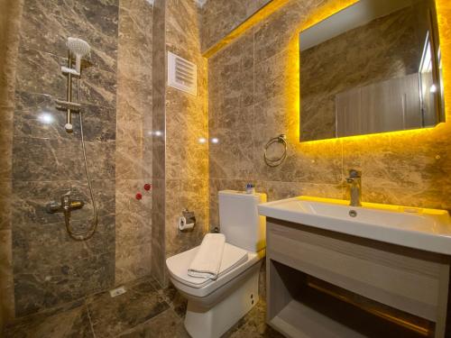 ein Badezimmer mit einem WC, einem Waschbecken und einem Spiegel in der Unterkunft Medos Hotel in Kusadası