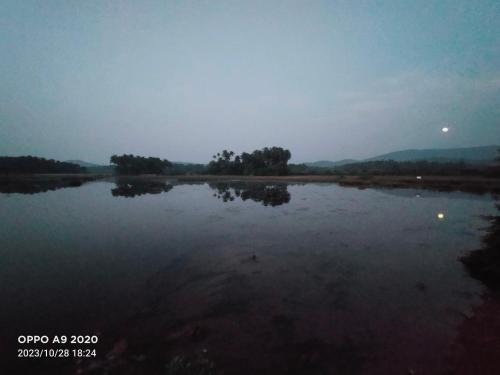 a large body of water with trees in the distance at Gokarna Outskirt Stays in Kumta
