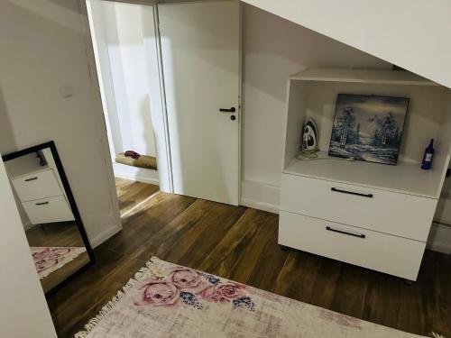 a bedroom with a white dresser and a mirror at SA Apartment in Gjilan