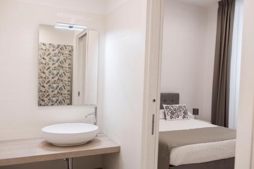 baño blanco con lavabo y cama en B&B Torre Canina suite & rooms, en Trani